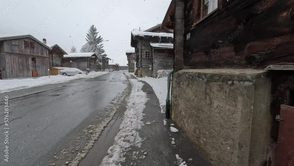 Walk along the roadside of Oberwald in Goms. Swiss mountain village during heavy snowfall in winter. No cars on the road. POV Walk along the roadside of Oberwald in Goms. Swiss mountain village during heavy snowfall in winter. No cars on the road. POV