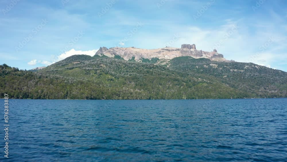 Low forward aerial over lake by forested mountains in Argentina Low forward aerial over lake by forested mountains in Argentina