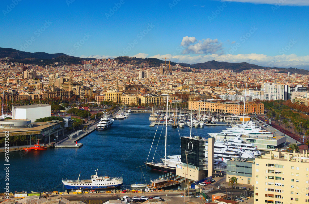 Barcelona, Spain-January 02,2016:Scenic aerial landscape view of Port Vell with moored yachts and ships. Downtown of Barcelona in the background. Travel and tourism concept. Cityscape at sunny day