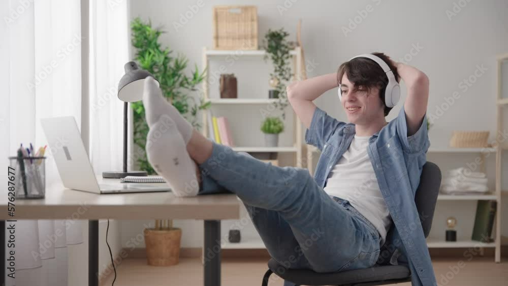 Teenager boy having casual video call on laptop sitting in relaxing position at home Teenager boy having casual video call on laptop sitting in relaxing position at home