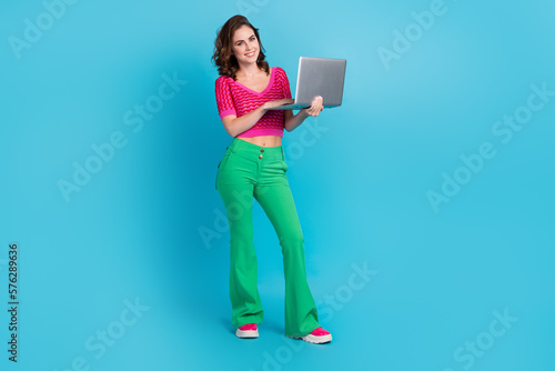 Full length photo of stunning lady wear trendy clothes hold netbook promote quality device empty space isolated on blue color background