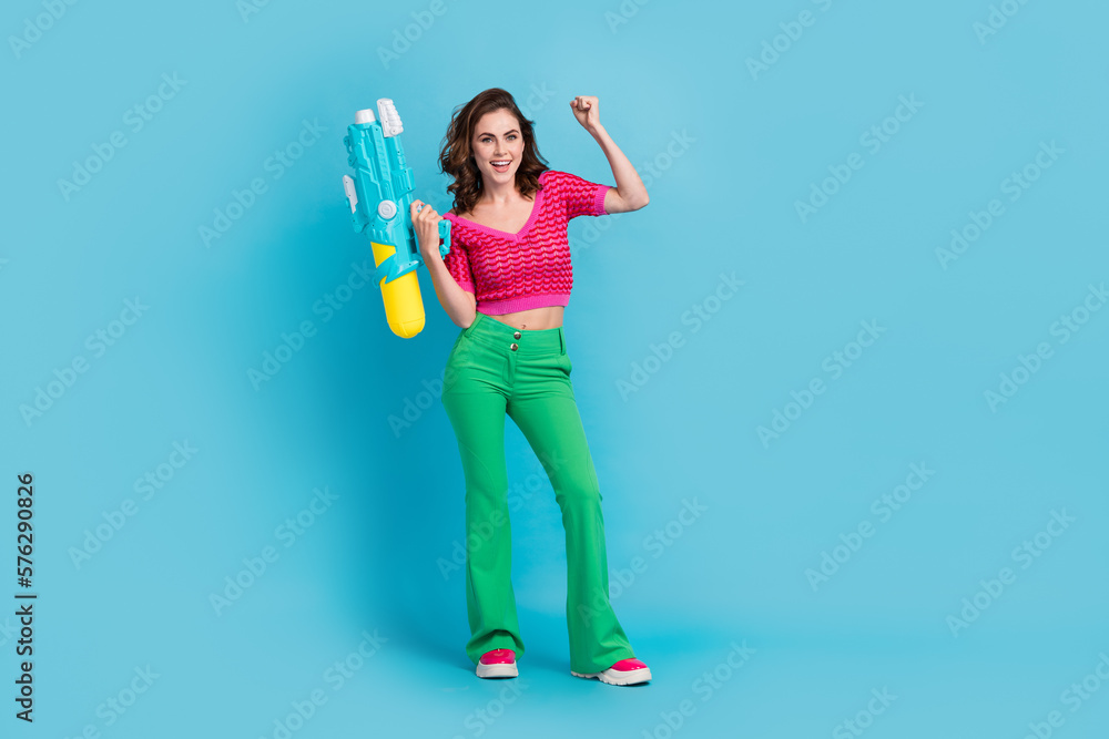 Full length photo of overjoyed funky lady wear trendy clothes celebrate win play game empty space isolated on blue color background Full length photo of overjoyed funky lady wear trendy clothes celebrate win play game empty space isolated on blue color background