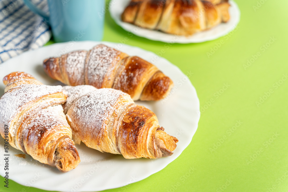 Close up of delicious chocolate croissants sprinkled with fine sugar. Sweet moment: croissants and coffee with chocolate. High quality photo