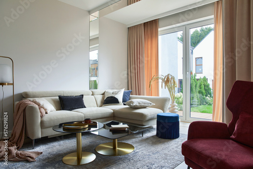 Creative living room interior composition with beige sofa, glass coffee table, carpet on the floor and glamorous accessories. Template. photo