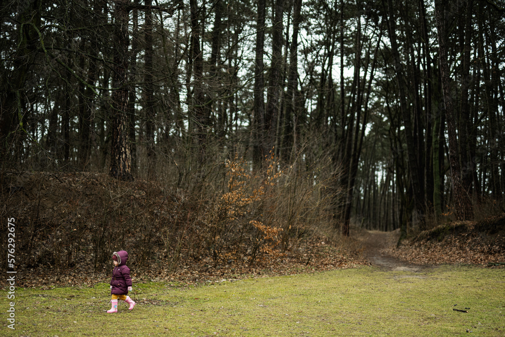 Baby girl walking along the forest after rain. Baby girl walking along the forest after rain.