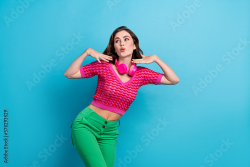 Photo of adorable pretty funky lady looking empty space ad offer rejoice dancing favorite songs melody isolated on blue color background