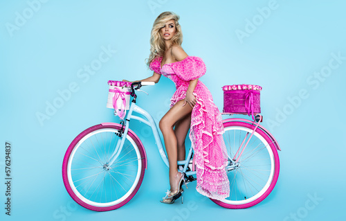Beautiful woman in spring dress on colorful bike decorated with flowers. Spring concept. © marcink3333