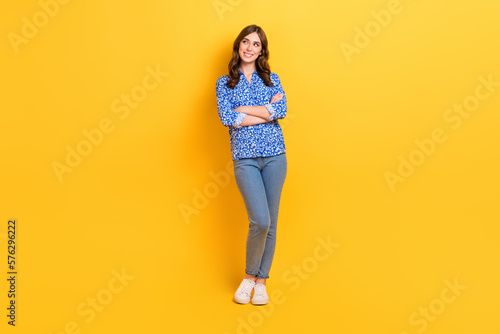 Full body photo of charming cheerful lady folded arms look empty space smart casual clothes isolated on yellow color background