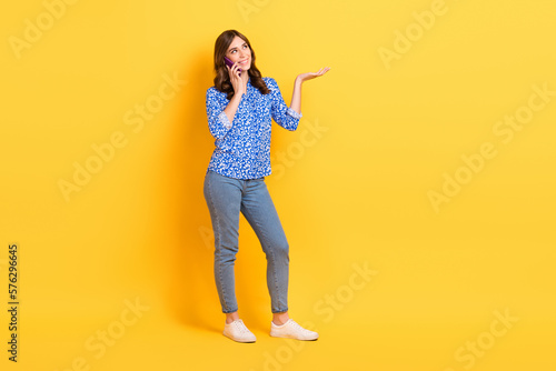 Full body photo of pretty cheerful lady speak communicate telephone smart casual outfit isolated on yellow color background