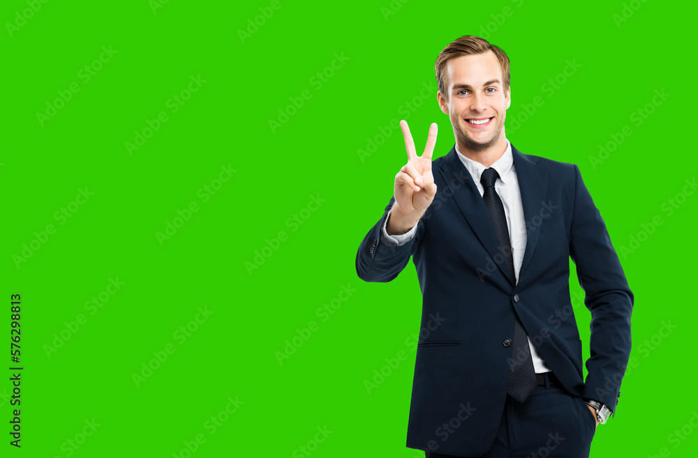 Excited businessman in black confident suit showing two fingers or victory sign gesture, green chroma key background. Happy gesturing man. Copy space for ad slogan or text. Excited businessman in black confident suit showing two fingers or victory sign gesture, green chroma key background. Happy gesturing man. Copy space for ad slogan or text.
