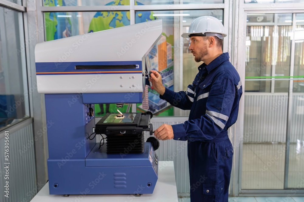 An engineer using optical micrometer quality checking micro part An engineer using optical micrometer quality checking micro part