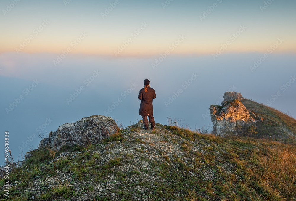 young woman stands on a rock above a river canyon. female tourist enjoys foggy autumn landscape. nature of Ukraine young woman stands on a rock above a river canyon. female tourist enjoys foggy autumn landscape. nature of Ukraine