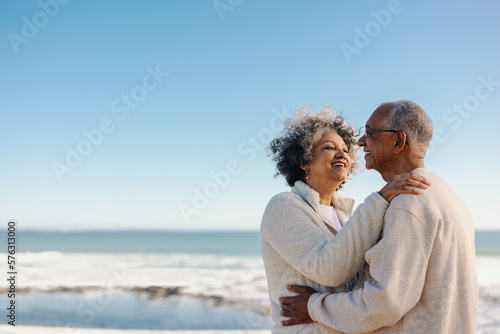 Retired senior couple smiling happily at the beach