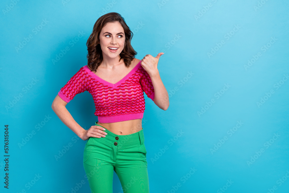 Photo of cheerful pretty lady wear pink trendy clothes showing empty space new collection sale isolated on blue color background Photo of cheerful pretty lady wear pink trendy clothes showing empty space new collection sale isolated on blue color background