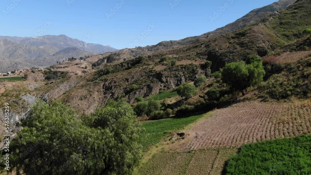 Aerial revealing Bolivian crops and farms on remote mountain side in high desert Andes Aerial revealing Bolivian crops and farms on remote mountain side in high desert Andes