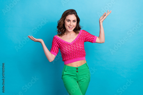 Photo of cheerful cute lady wear bright summer clothes showing arms dont know answer sorry isolated on blue color background