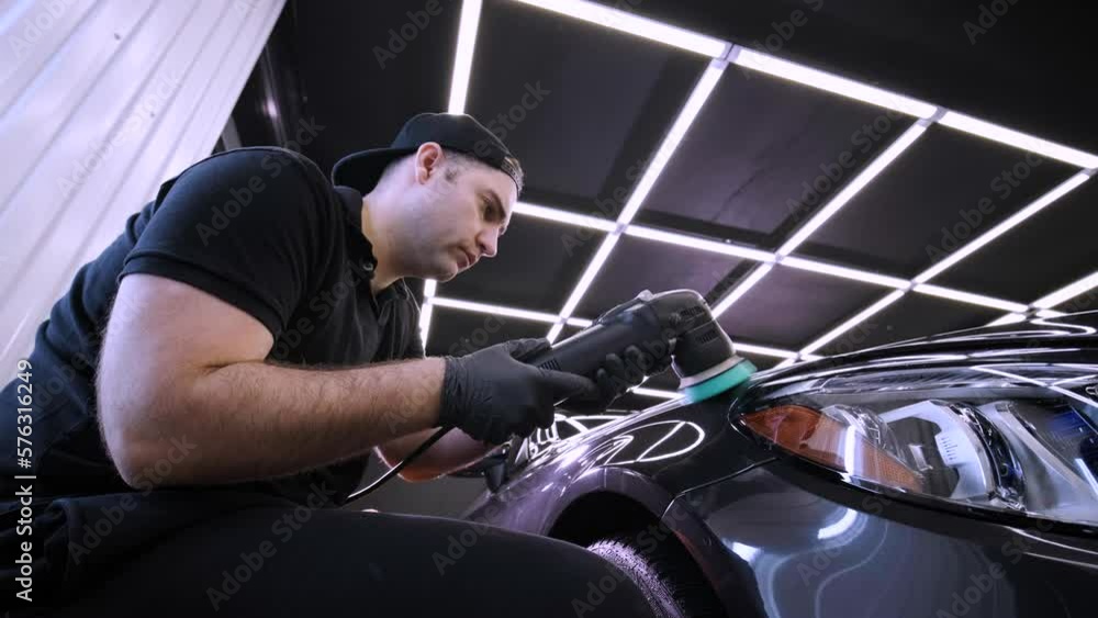 Vidéo Stock Worker polish a black car. Car detailing man are using