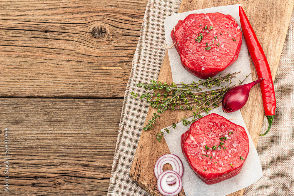 Raw Eye of round steak with spices and herbs on wooden background. Fresh meat for cooking food Raw Eye of round steak with spices and herbs on wooden background. Fresh meat for cooking food
