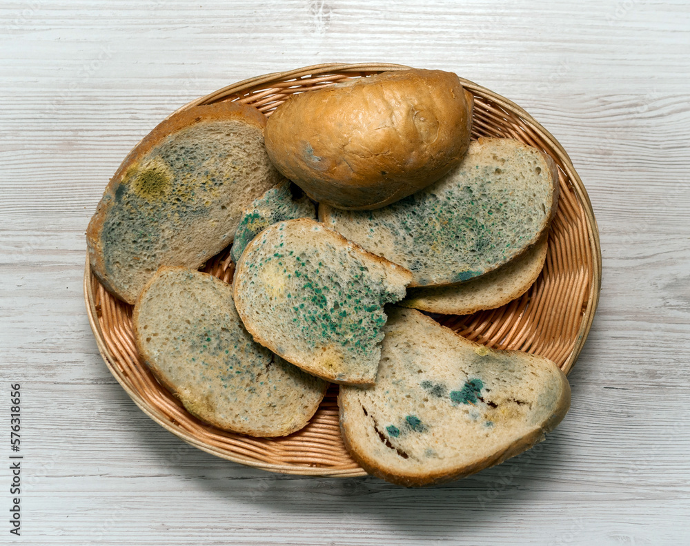 Bread with mold in a basket of straw on a light wooden table, bread ...