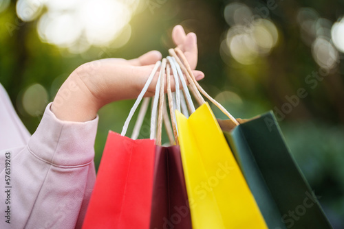 Close up hand holding colorful shopping bag, Shopaholic..