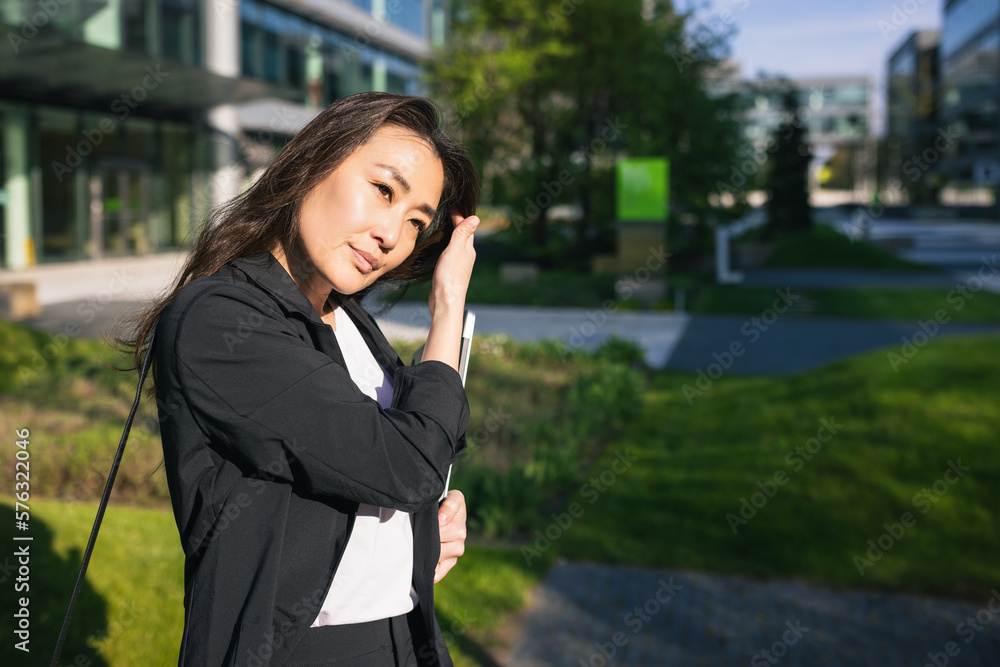 Tired overworked Asian business woman in suit with laptop outdoor Tired overworked Asian business woman in suit with laptop outdoor