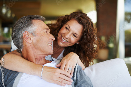 I love you. A handsome mature man being lovingly embraced by his smiling wife.