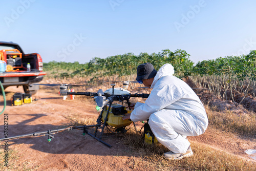 Farmer stop fly drone at ground to replace empty battery at the rice field hi technology agriculture