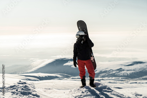Hobby snowboarding in winter gear, going to conquer the top of the mountain on a snowboard.