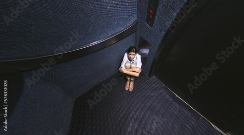 Nothing to do but wait. Distorted shot of a young woman trapped in an elevator. photo
