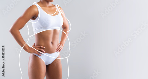 Millennial slim african american lady in white lingerie enjoys weight loss result with fat abstract body around