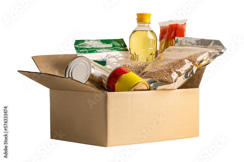 Foodstuff for donation isolated on white background with clipping path, storage and delivery. Various food, pasta, cooking oil and canned food in cardboard box. photo