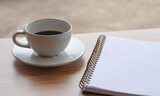 Blank notebook  and coffee cup on wooden table