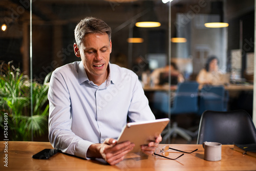 Portrait of businessman in office. Man using digital tablet. Businessman having video call..