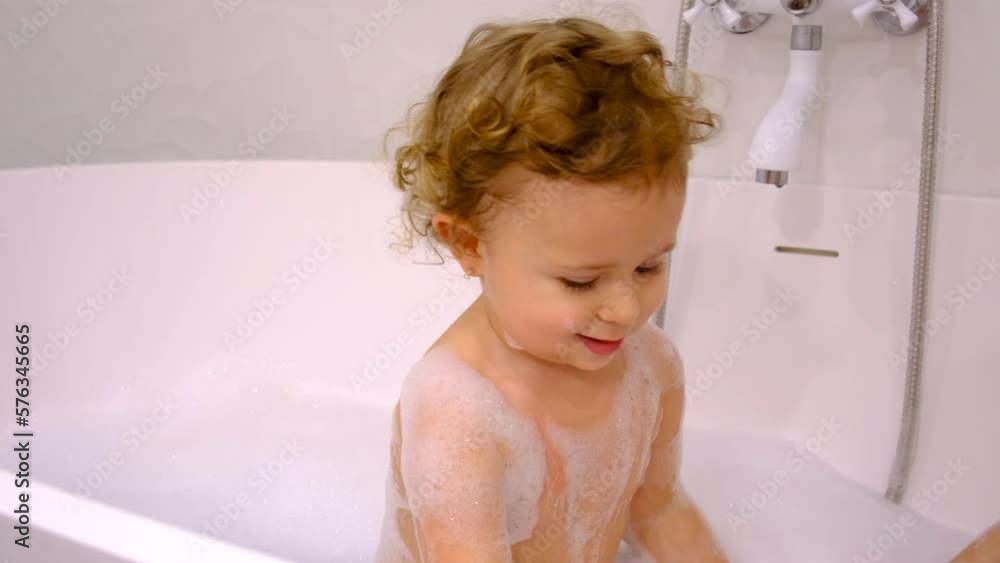 A child bathes in a bubble bath. Selective focus. A child bathes in a bubble bath. Selective focus.