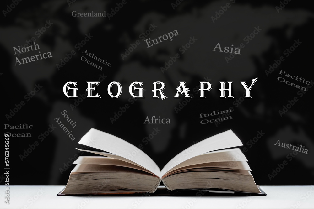 The study of geography. An open book, a textbook lies on the table. Map