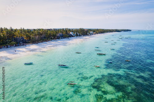 Behold the breathtaking aerial footage of Zanzibar's Kiwengwa beach, a tropical paradise with swaying palms and crystal-clear waters