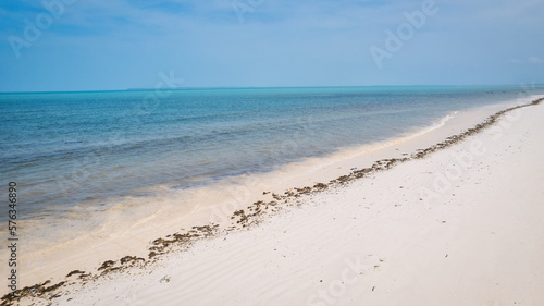 The aerial view of Zanzibar's Indian Ocean coastline is simply stunning, featuring palm trees, white sand, and sparkling blue waters. With luxurious hotels and a tropical landscape, it is the perfect 