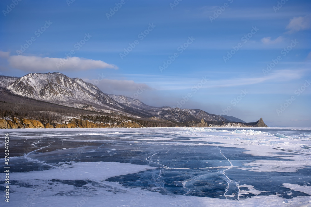 Shore of the lake and black ice with cracks, winter Baikal. Russia. Shore of the lake and black ice with cracks, winter Baikal. Russia.