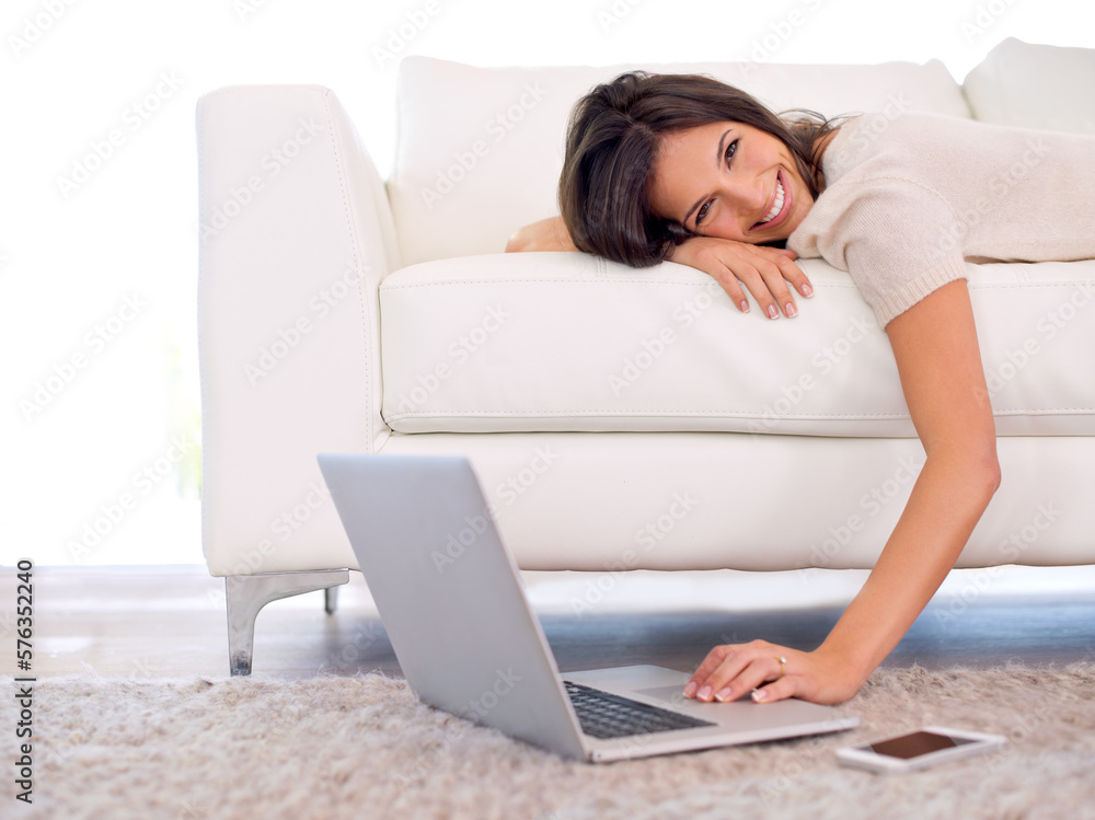 Enjoying some luxury while keeping connected. Cropped shot of a gorgeous young woman lying on a couch using a laptop. Enjoying some luxury while keeping connected. Cropped shot of a gorgeous young woman lying on a couch using a laptop.