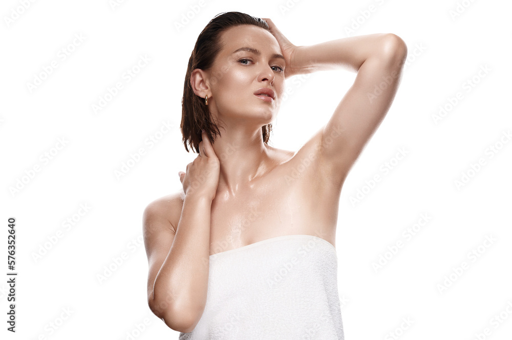 An enticing female with natural, glowing skin and damp tresses, covered by a towel on an isolated white backdrop. A captivating fresh beauty shot An enticing female with natural, glowing skin and damp tresses, covered by a towel on an isolated white backdrop. A captivating fresh beauty shot