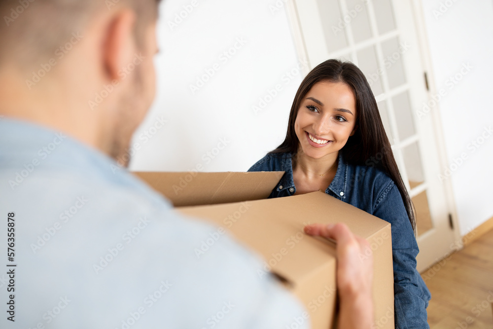 New Home And Relocation. Happy Couple Carrying Cardboard Box With Belongings, New Home And Relocation. Happy Couple Carrying Cardboard Box With Belongings,