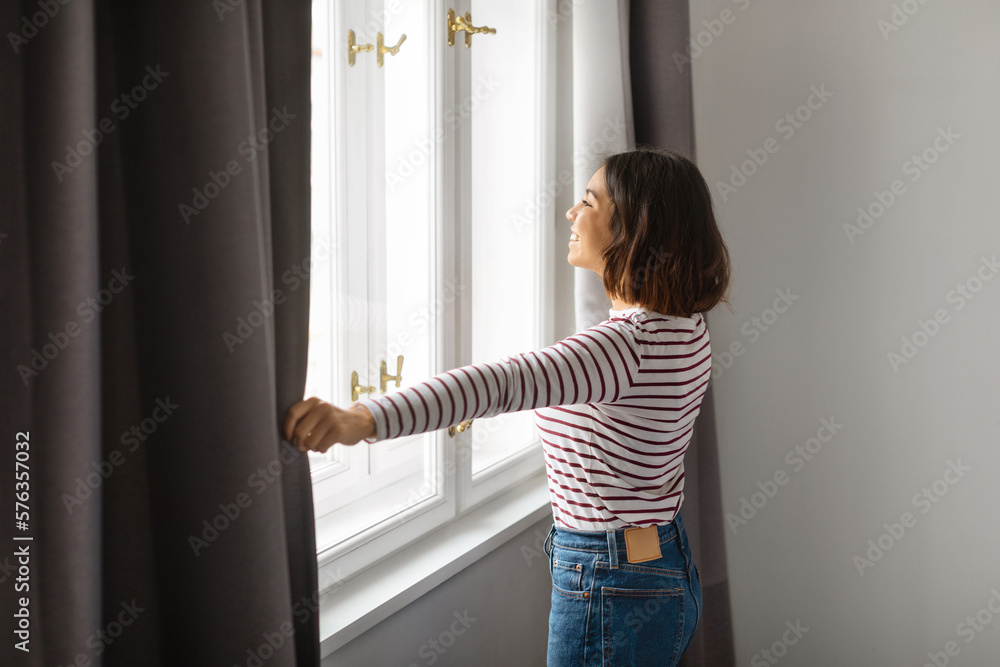 Start New Day. Young Smiling Arab Woman Opening Curtains At Home Start New Day. Young Smiling Arab Woman Opening Curtains At Home