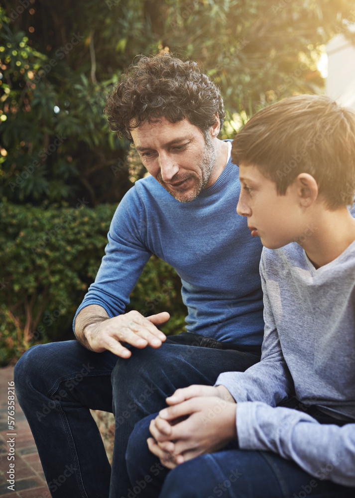 © Mariusz/peopleimages.com - Dad knows best. Shot of a father and son having a heart to heart in the backyard. © Mariusz/peopleimages.com - Dad knows best. Shot of a father and son having a heart to heart in the backyard.