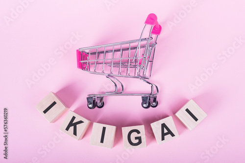 Ikigai - interpretation of Japanese concept - a reason for being as a balance between love, skills, needs and money - concept on wooden cubes with shopping trolley photo