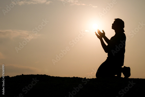 Silhouette of man praying for god's blessing. hope concept