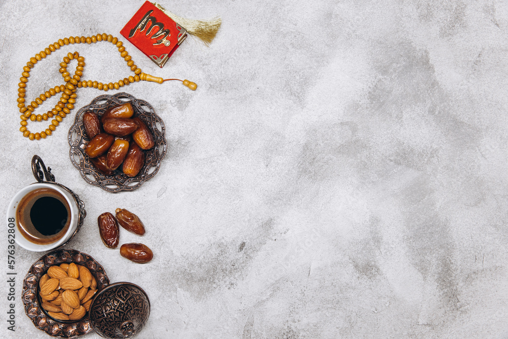 Table top view image of decoration Ramadan Kareem, dates fruit, cup of coffee and almond on gray stone background. Flat lay with copy space. Table top view image of decoration Ramadan Kareem, dates fruit, cup of coffee and almond on gray stone background. Flat lay with copy space.