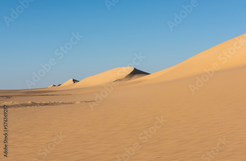 Barren desert landscape in hot climate with sand dunes