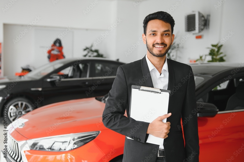 indian cheerful car salesman at showroom. indian cheerful car salesman at showroom.