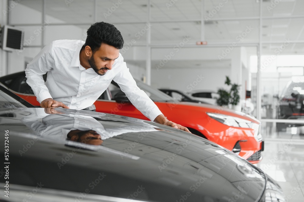 happy indian man buy new biodiesel eco automobile in lux showroom. happy indian man buy new biodiesel eco automobile in lux showroom.