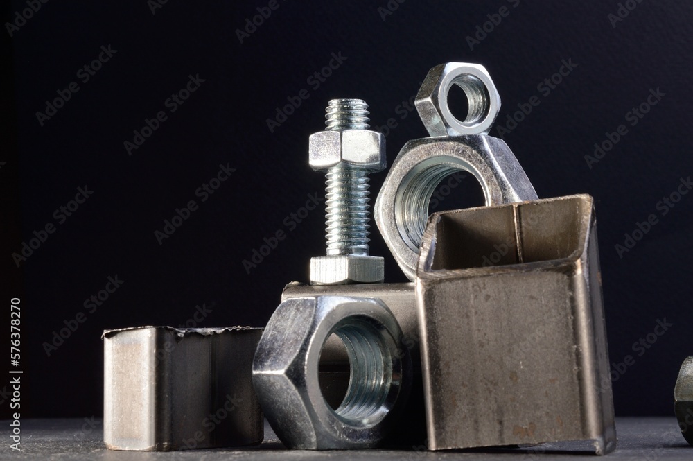 composition of nuts bolts and scraps of metal laid out on a dark background. composition of nuts bolts and scraps of metal laid out on a dark background.
